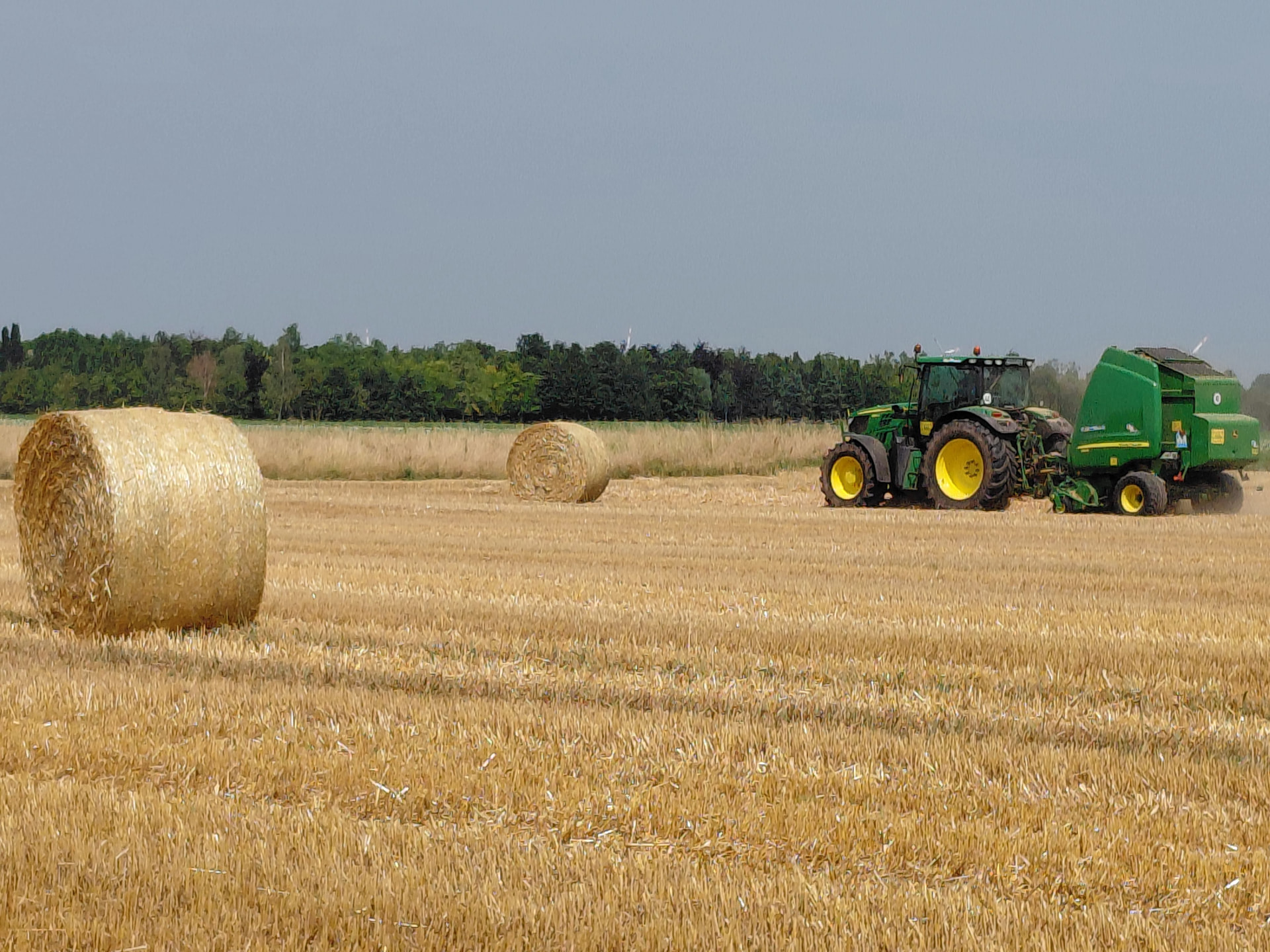 Tractor baling a harvested field